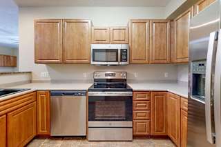 A kitchen with wooden cabinets and stainless steel appliances.