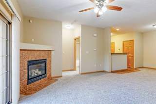 A living room with a fireplace and a ceiling fan.