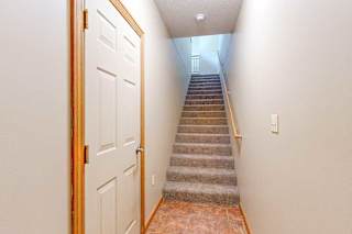 An entryway with a door to the attached garage, and a staircase that leads up to the living room.