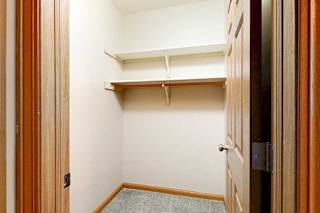 A walk-in closet with two shelves and hanging space.