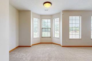 A dining room off a living room with a bay window.