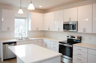 A spacious kitchen with white cabinets and stainless steel appliances.