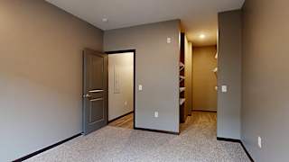 a bedroom with a walk-in closet with built-in shelving and hanging space