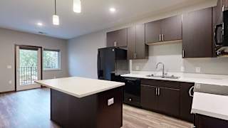a kitchen with dark brown cabinets and a white granite island