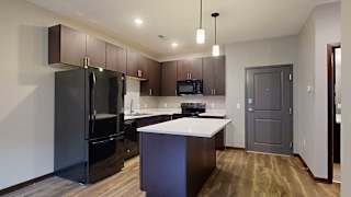 a kitchen with dark cabinets, black appliances, and granite countertops