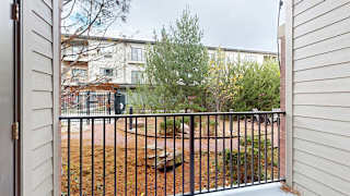 an elevated patio with a metal railing overlooking a courtyard