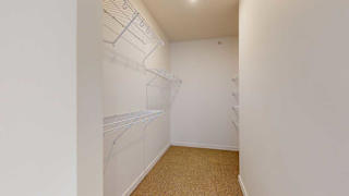 a large walk in closet with built-in shelving and hanging space