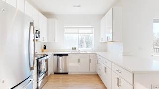Furnished apartment kitchen with white finish style and stainless steel appliances