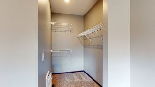 Walk in closet with plenty of shelving and hanging space in a furnished apartment at the conrad