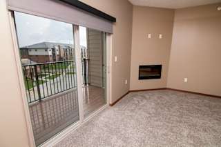 A living room with a fireplace and sliding glass doors to balcony