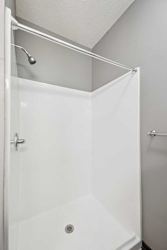 A bathroom with a walk-in shower with chrome fixtures.