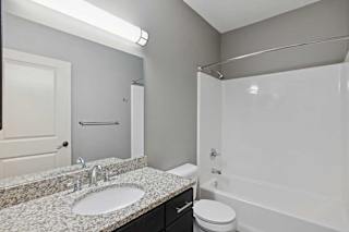 A bathroom with a sink, toilet, and bathtub.