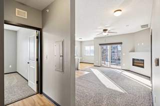 A modern open doorway leads to a living room with a fireplace.