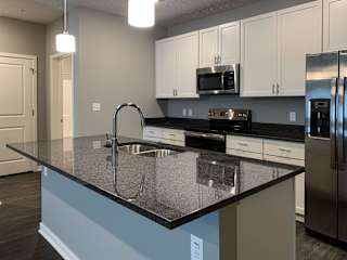 Large kitchen island with granite countertops and sink