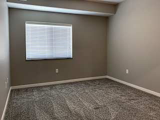 Bedroom with large window to allow natural light in the buffalo floorplan at the flats at shadow creek