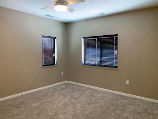 Carpeted bedroom with two windows on either wall