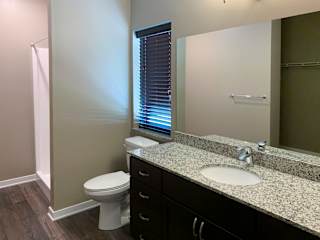 Bathroom with dark brown vanity and large mirror