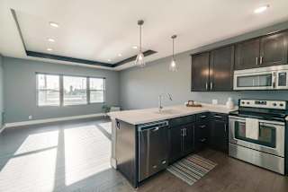 A modern kitchen with stainless steel appliances and wooden cabinets.