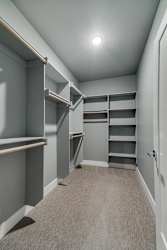 A room with grey walls and a carpeted floor with a white door on the right.