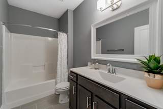 A bathroom with a white tub, sink, and toilet.