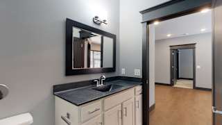 bathroom with white cabinetry and mirror