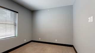 a bedroom with gray walls and a window