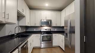 a kitchen with white cabinets and stainless steel appliances