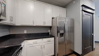 a kitchen with white cabinets and a stainless steel refrigerator