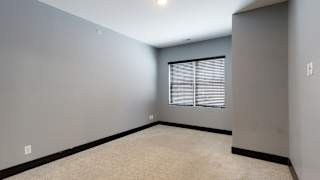 a bedroom with gray walls and a large window