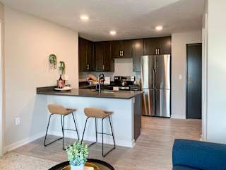 a kitchen with a large island with two stools in front of it