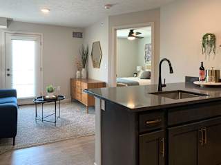 a kitchen with an island and a living room in the background