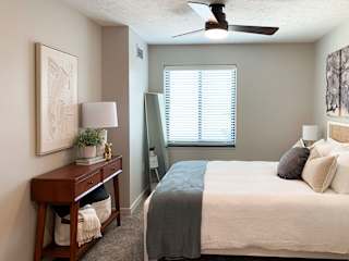 a bedroom with a ceiling fan and a window
