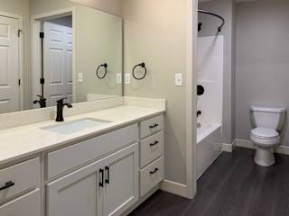 bathroom with a white sink, tub, shower, and toilet.