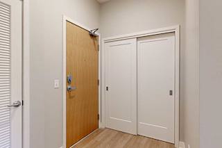 A front entryway with a wooden front door and a sliding door coat closet.