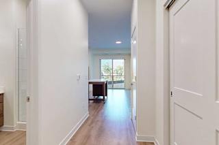 Apartment entryway with white walls and a bathroom to the left