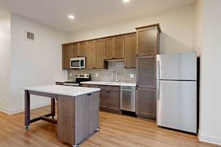 A kitchen with a white counter top and a stainless steel refrigerator.