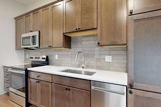 A kitchen with brown cabinets and a white countertop.