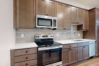 A kitchen with wooden cabinets and a stainless steel appliances