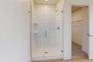 A white bathroom with a glass shower stall.