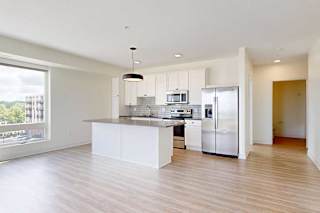 A modern kitchen with white cabinets and stainless steel appliances.
