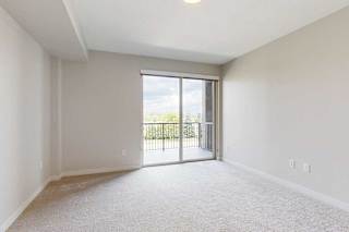 A bedroom with a sliding glass door leading to a balcony.
