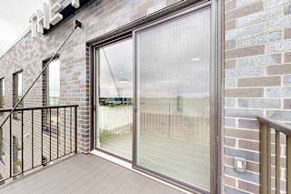 A balcony with a glass door and a metal railing.
