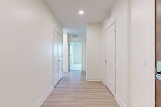 A long hallway with white walls and wood floors.