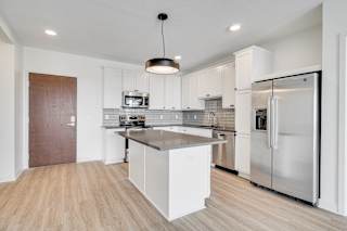 Large kitchen with countertop island white cabinets and matching stainless steel appliances at The Rowan Apartments in Eagan Minnesota