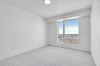 Spacious carpeted bedroom with large window allowing a lot of natural light in at The Rowan apartments in Eagan Minnesota