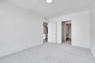 Spacious white carpeted bedroom with walk in closet and access to bathroom at The Rowan in Eagan Minnesota