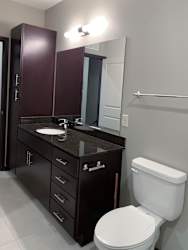 Bathroom with dark brown vanity and linen closet and large mirror