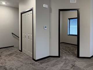 View of den from the outside next to closet and staircase entry