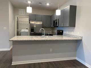 A kitchen with a granite countertop and stainless steel appliances.