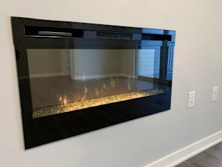 A black fireplace with a fire burning inside.
